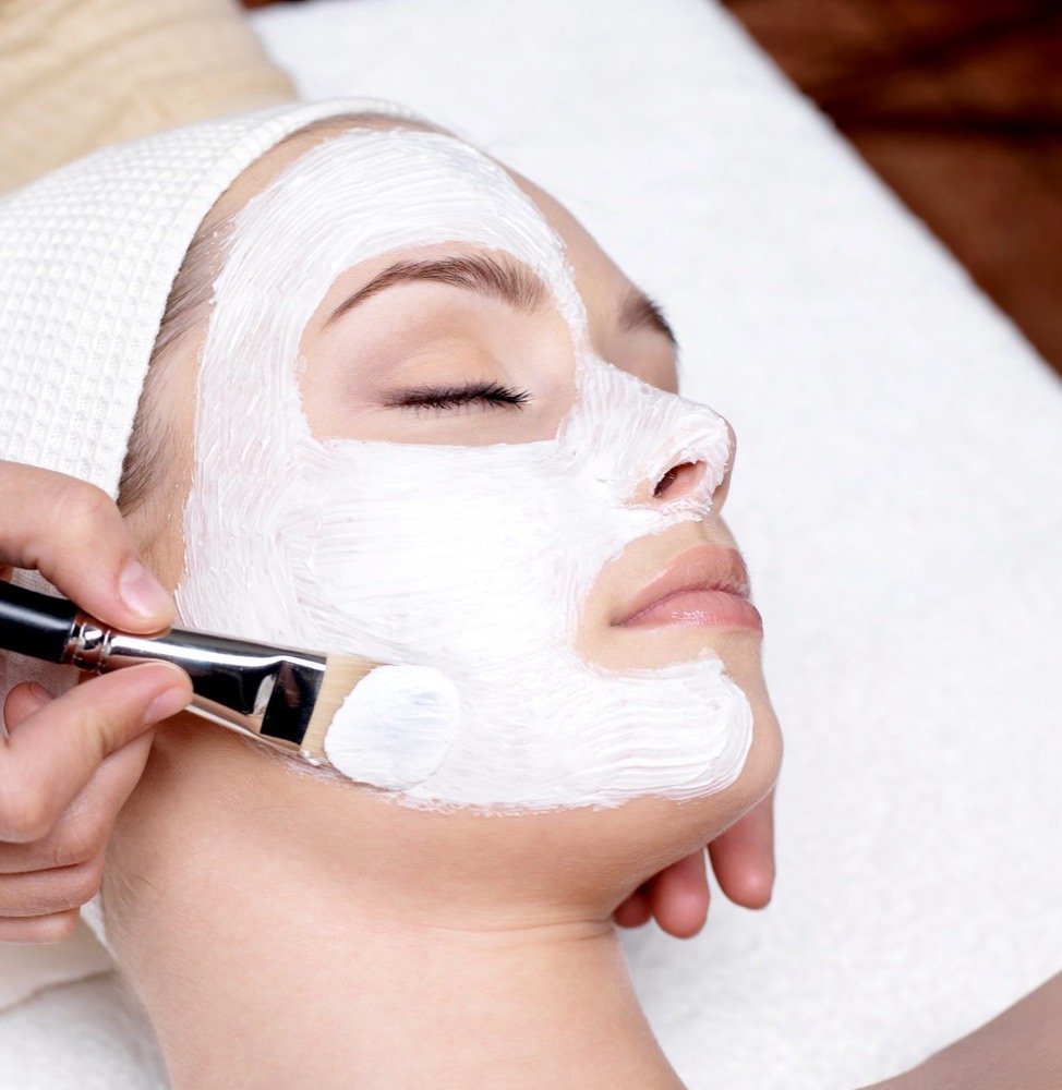 A relaxing facial mask being applied with a brush